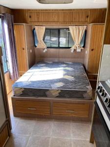 una cama en la parte trasera de una caravana en Private Caravan and facilities - Tarzali Valley Veiws, en Tarzali