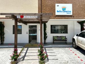 un panneau devant un bâtiment fleuri dans l'établissement Bella Catarina Bombinhas, à Bombinhas