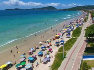 a beach with many umbrellas and people on the beach at Bella Catarina Bombinhas in Bombinhas