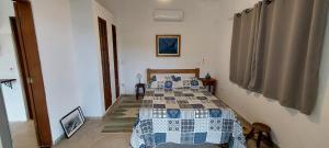 1 dormitorio con 1 cama con edredón en Villa Girassol en Ilhabela