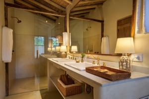 a bathroom with two sinks and a large mirror at Na Praça Hotel in Trancoso