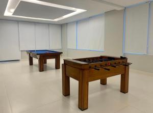 una habitación con 2 mesas y una mesa de billar en Flat Palladium, en São Vicente