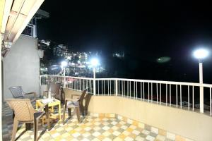 a patio with chairs and tables on a balcony at night at OYO Hotel Sai Stay Inn in Chhota Simla