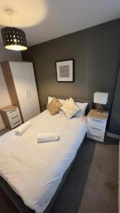 a large white bed with two towels on it at Stunning Manchester City Centre Apartment! Ideal for small groups in Manchester