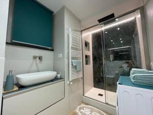 a bathroom with a sink and a glass shower at Il Giardino di Iris in Genova