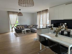 eine Küche und ein Wohnzimmer mit einem Sofa und einem Tisch in der Unterkunft Logement moderne et spacieux ! in Prilly
