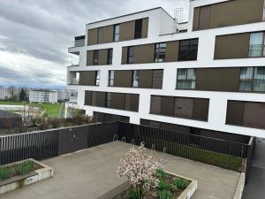 ein großes weißes Gebäude mit schwarzen Fenstern in der Unterkunft Logement moderne et spacieux ! in Prilly