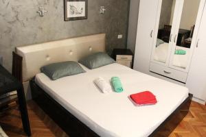 a white bed with two pillows and a mirror at Villa Old Town in Podgorica
