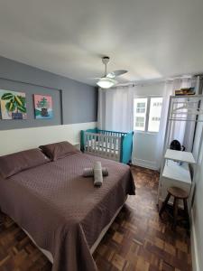 um quarto com uma cama com um edredão castanho em Prédio frente mar 3 quartos Balneário camboriú BrisaMarBC3 no Balneário Camboriú