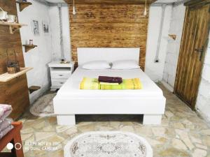 a bedroom with a white bed and a wooden wall at Villa Old Town in Podgorica