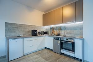 a kitchen with white cabinets and stainless steel appliances at Stacja Mazury(Masuria Station) in Narty +64 photos