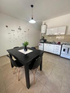 a kitchen with a black table and chairs in a room at Apart Entre Valles in Chilecito