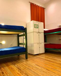 a room with two bunk beds and a refrigerator at Hostel Alvear in Córdoba