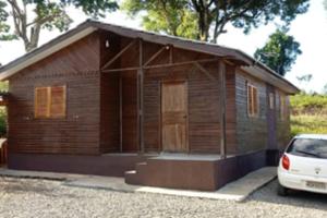 una piccola casa in legno con un'auto parcheggiata di fronte di Morada do Lago Raio de Sol a Machadinho