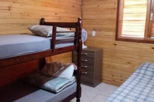 a room with two bunk beds in a cabin at Morada do Lago Raio de Sol in Machadinho