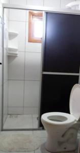 a bathroom with a toilet and a glass shower at Cabana econômica para 12 pessoas in Machadinho
