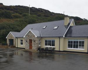 a house with tables and chairs in a parking lot at Everest Lodge Guest House in Dunfanaghy