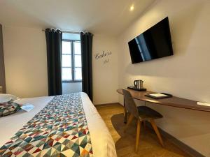 1 dormitorio con 1 cama y escritorio con TV en Best Western Le Pont d'Or en Figeac