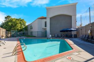 a swimming pool in front of a building with a house at Best Western Lanai Garden Inn & Suites in San Jose