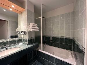Best Western Le Pont d'Or في فيجيا: حمام مع حوض وحوض استحمام