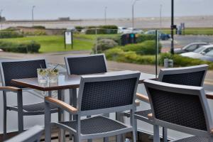 a table and chairs on a balcony with a view of a parking lot at Best Western Lancaster Morecambe Lothersdale Hotel in Morecambe
