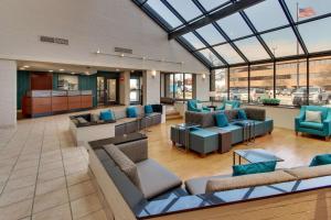 un hall avec des canapés et des chaises dans un bâtiment dans l'établissement Pear Tree Inn St. Louis Airport, à Edmundson