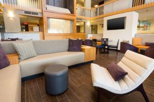 a lobby with a couch and chairs and a tv at Drury Inn & Suites Austin North in Austin