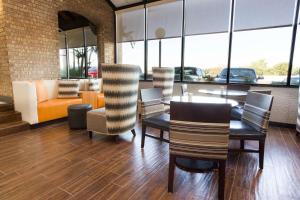 Drury Inn & Suites Austin North في أوستن: غرفة طعام مع طاولة وكراسي وأريكة