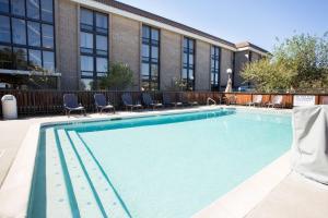 a large swimming pool with chairs in front of a building at Drury Inn & Suites Austin North in Austin