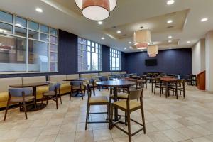 a dining room with tables and chairs and windows at Drury Inn & Suites St. Louis Arnold in Arnold