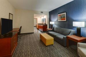 a hotel room with a couch and a television at Drury Inn & Suites St. Louis Arnold in Arnold