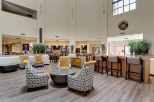 a lobby with chairs and tables and a bar at Drury Inn & Suites Phoenix Airport in Phoenix