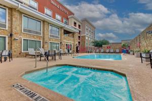 a swimming pool with chairs and a building at Drury Inn & Suites San Antonio Airport in San Antonio