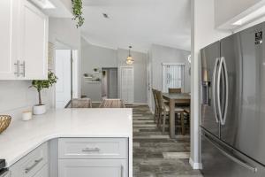 a kitchen with a refrigerator and a dining room at Villa Maria Salt Sun 7 minutes to Indian Rocks Beach in Largo