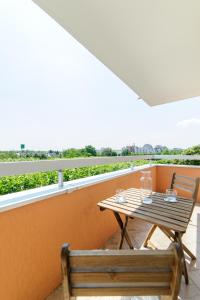 a wooden table and a bench on a balcony at Le Marnois-Gare in Noisy-le-Grand