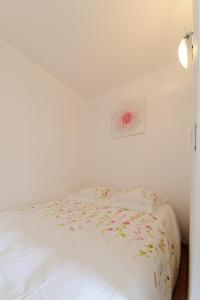 ノワジー・ル・グランにあるLe Marnois-Gareのベッドルーム1室(花が咲く白いベッド1台付)