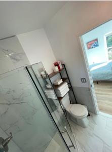 y baño con aseo y ducha acristalada. en Santoniri private room en Seattle