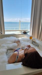 a woman laying in a bathtub covered in foam at Oceanfront Serenity in Gated Community near Rosarito in Harry Manzo