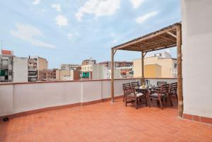 a patio with a table and chairs on a roof at Apartamentos Turísticos Tenor by Bossh! Hotels in Barcelona