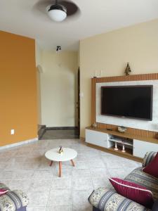 sala de estar con TV, sofá y mesa en Casa Bençaos de Aparecida, en Aparecida