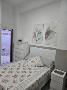 a bedroom with a bed and two pictures on the wall at Habitacion en casa de familia "ValenciaBonita" in Valencia
