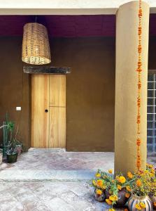 una puerta delantera de una casa con flores y una luz en CASA PENUMBRA- Centro Oaxaca, en Oaxaca City