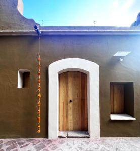 un edificio con una puerta de madera en un lateral en CASA PENUMBRA- Centro Oaxaca, en Oaxaca City