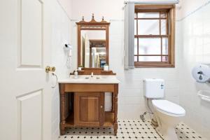 a bathroom with a sink and a toilet and a mirror at Double Room in Gordon near Train & Bus - 1 person in Pymble