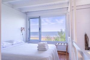 1 dormitorio con 1 cama y vistas al océano en Refugios del sauce en Monte Hermoso