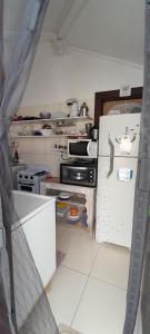 una pequeña cocina con nevera abierta. en Hospedagem Tucanos en Búzios