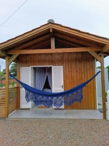 a hammock in front of a dog house at Cabanas MORIÁ in Garopaba