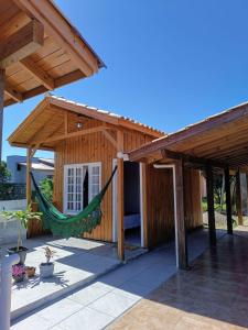 eine Hängematte in einem Holzhaus mit Dach in der Unterkunft Cabanas MORIÁ in Garopaba