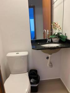 a bathroom with a white toilet and a sink at Apartamento encantador próximo a Praia Brava in Matinhos +28 photos