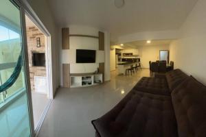 a living room with a couch and a dining room at Apartamento encantador próximo a Praia Brava in Matinhos